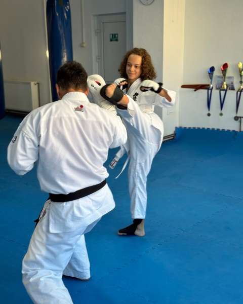 Junioară lovind în mănușile de țintă la antrenament – Kyokushin, Zanshin Dojo Brașov